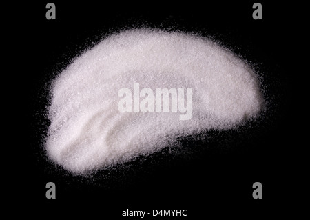 Bianco zucchero chrystals polvere su sfondo nero Foto Stock
