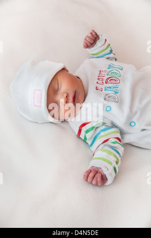 Baby girl (8 giorni) prese in un soffice luce (luce tenda). Hat legge "carino" e top legge 'I love Daddy'. Foto Stock