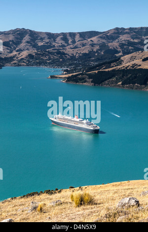 Cunard crociera Queen Mary 2 al di ancoraggio in acque profonde nel porto di Akaroa, vicino a Christchurch, Nuova Zelanda. Foto Stock