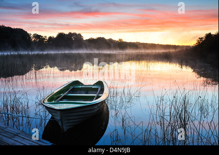 Barca vuota su acqua a sunrise, Rådasjön, Mólndal, Svezia, Europa Foto Stock