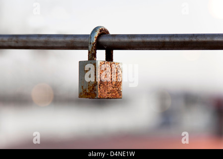 Il lucchetto chiuso in un arrugginito asta di ioni. Foto Stock