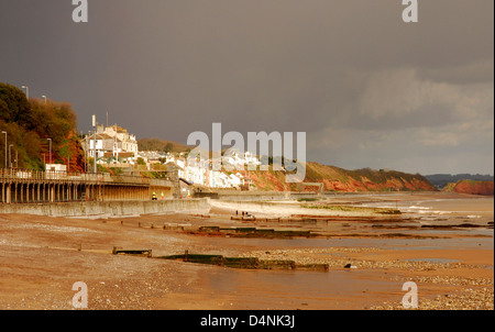 Devon - dawlish beach e dal lungomare di edifici - il drammatico nuvole temporalesche - sole invernale Scegliendo lungomare - dark Red cliffs. Foto Stock