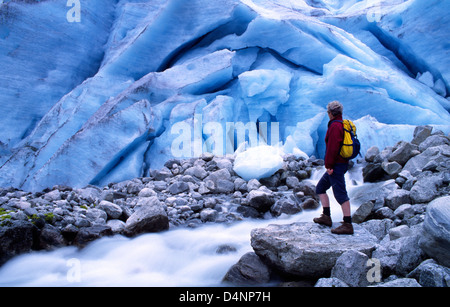 Il camminatore femmina in piedi accanto al ghiacciaio Bodalsbreen, vicino Loen, Sogn di Fjordane, Norvegia. Foto Stock