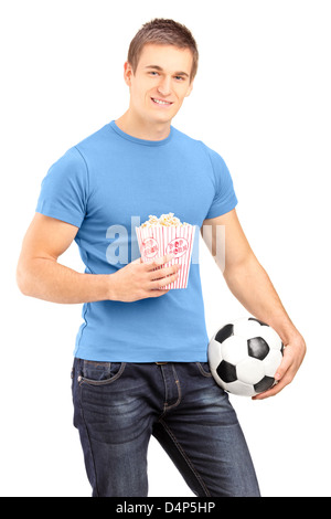 Maschio ventola sport tenendo un calcio e popcorn box isolati su sfondo bianco Foto Stock