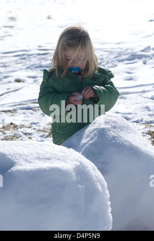 Bambino toddler baby ragazza bionda passeggiate e giocare nel paesaggio innevato - Montagna invernale Foto Stock