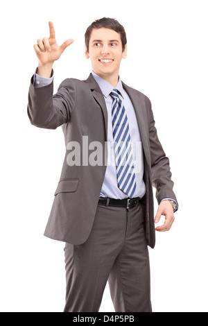 Giovane imprenditore di toccare qualcosa di immaginario isolati su sfondo bianco Foto Stock