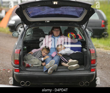 Una donna e i suoi due figli siedono nel bagagliaio di una guida Opel Omega nei locali della Motorsport Arena durante un incontro di Opel di Oschersleben, Germania, 06 giugno 2009. Decine di migliaia di appassionati e alcuni 20.000 autovetture provenienti da tutta Europa sono attesi per lo spettacolo. Tuning e competizioni di guida e un classico auto rallye sono pianificate durante l'evento. Vi sarà inoltre ancora t Foto Stock