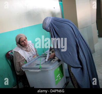 Una donna afghana getta il suo voto in corrispondenza di una stazione di polling in una moschea di Kabul, Afghanistan, 20 agosto 2009. È la seconda volta circa 12 milioni di afghani sono idonei a votare un nuovo presidente dopo la distruzione del regime dei talebani. Foto: Marcel Mettelsiefen Foto Stock