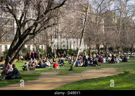 I londinesi relax al sole primaverile in Gordon Square, Bloomsbury, Londra Foto Stock