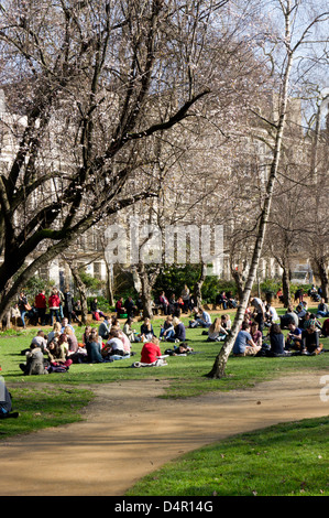 I londinesi relax al sole primaverile in Gordon Square, Bloomsbury, Londra Foto Stock