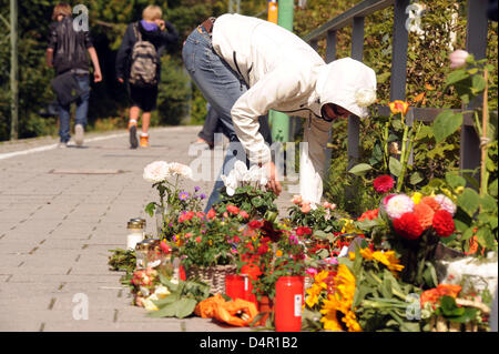 Una giovane donna si trova verso il basso i fiori alla stazione dove un passeggero era stato brutalmente picchiato a morte da due adolescenti a Monaco di Baviera, Germania, il 15 settembre 2009. I tentativi di rivitalizzare il 50-anno-vecchio non aveva avuto successo che è morto della sua gravi lesioni. Il procuratore pubblico?s ufficio ha emesso un mandato di arresto sul conto di omicidio. Foto: FELIX HOERHAGER Foto Stock