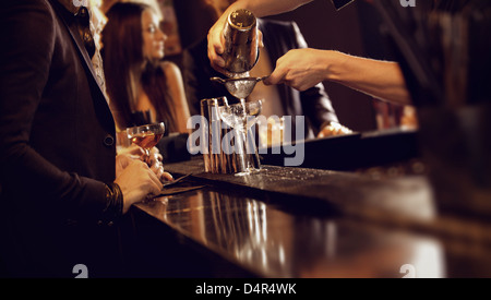 Barista usando un agitatore e versando il vino nel bicchiere di vino Foto Stock