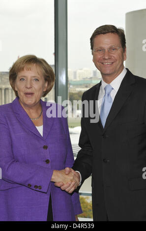 Angela Merkel, il Cancelliere tedesco e leader del conservatore cristiano democratico partito Unione (CDU) e Guido Westerwelle, leader della pro-business Liberi Democratici (FDP) agitare le mani alla cancelleria a Berlino, Germania, 28 settembre 2009. Merkel i conservatori del giurato il lunedì per sigillare una coalizione trattativa, compresi i tagli fiscali con il pro-business Liberi Democratici (FDP) entro un mon