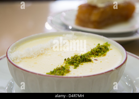 Tradizionale dessert turco Sutlac fatta con il latte di riso e farina, servita con pistacchio e cocco crolla. Foto Stock