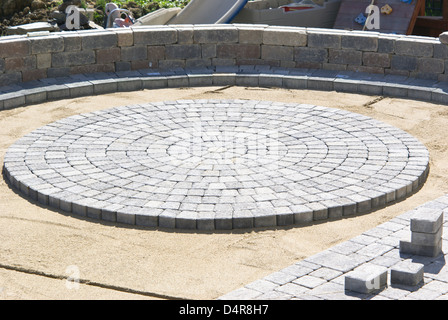 Cerchio di pavimentazione lastricatore di progettazione nel patio, sulla sabbia. Foto Stock