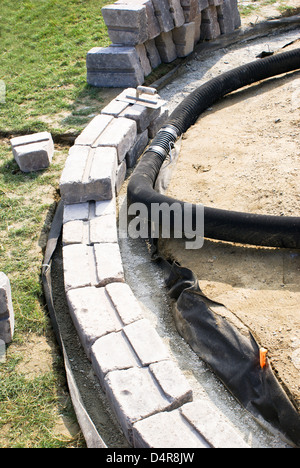 Patio muro di base sulla ghiaia con tubo corrugato. Foto Stock