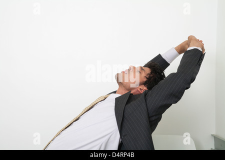 Esaurito metà-imprenditore adulti stretching con gli occhi chiusi Foto Stock