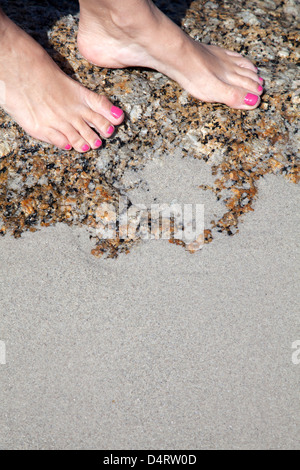 Donna con i piedi sul Beach rock Foto Stock