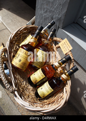 Un cestello di Calvados bottiglie al di fuori di un negozio in Honfleur, in Normandia. Foto Stock