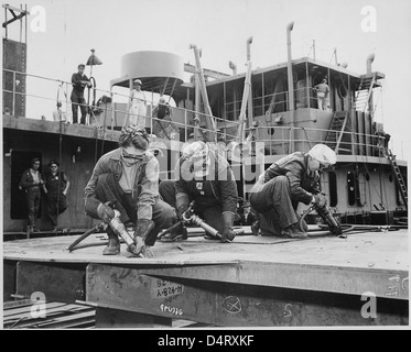 Fiocchi in un cantiere navale [costruzione navale. Tre donne che lavorano], 1942 Foto Stock