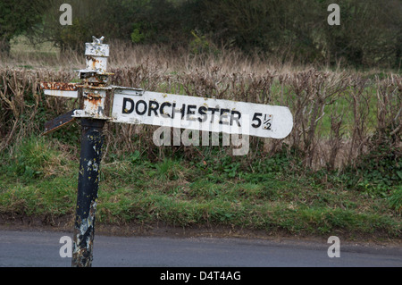 Inglese cartello stradale. "Dorchester 5 ½ miglia". Un vecchio fatiscente fingerpost accanto a un vicolo del paese in zone rurali Dorset, Inghilterra, Regno Unito. Foto Stock