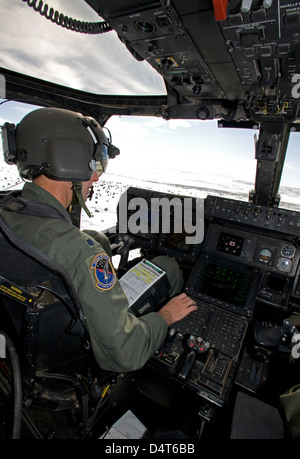 Pilota di un CV-22 Osprey va oltre i suoi strumenti nel cockpit. Foto Stock