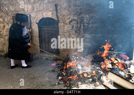 Gli ebrei ortodossi la masterizzazione di pane e Chametz come parte dei preparativi per le vacanze di Pasqua a Gerusalemme, Israele. Foto Stock