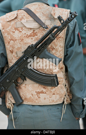 Un AK-47 poggia sull'imbracatura di una polizia afgana Officer durante la visita a una stazione di polizia locale a Kunduz, Afghanistan. Foto Stock