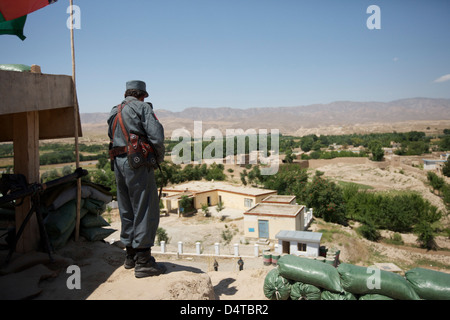 Poliziotto afghano permanente al suo checkpoint, Kunduz, Afghanistan. Foto Stock