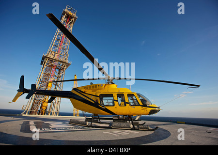 Una campana 407 elicottero utility su elisuperficie di un impianto di trivellazione petrolifera. Foto Stock