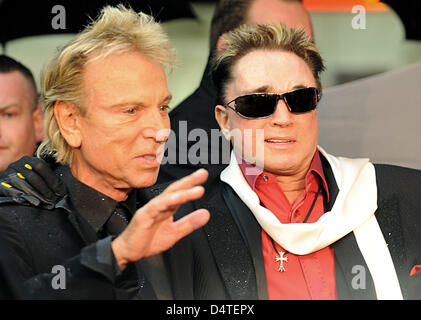 Maghi Siegfried (Siegfried Fischbacher - L) e Roy (Roy clacson) pone sul tappeto rosso nella parte anteriore del Hansa Variete teatro ad Amburgo, Germania, 29 ottobre 2009. Gli ospiti dalla politica, economia e società ha celebrato la premiere del nuovo programma di Hansa Variete Teatro. Foto: Marcus Brandt Foto Stock