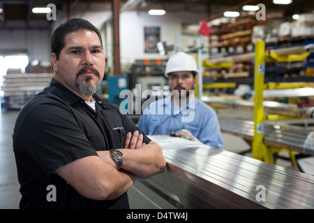 Lavoratore in piedi nella pianta di metallo Foto Stock