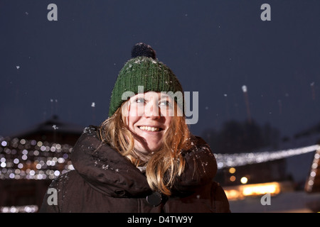 Donna sorridente in piedi nella neve Foto Stock