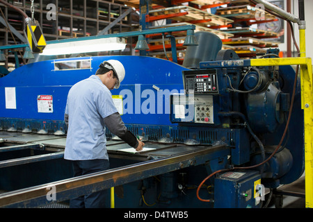 Lavoratore utilizzando macchinari di impianto in metallo Foto Stock