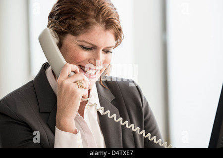 Sorridente imprenditrice parlando al telefono Foto Stock