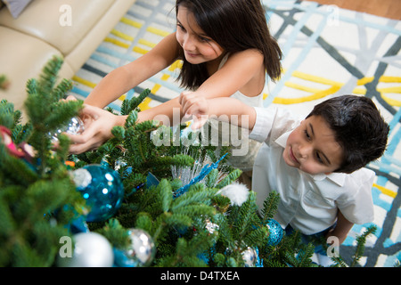 Bambini decorare albero di Natale Foto Stock