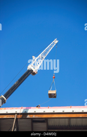 Il caricamento con gru attrezzature su edificio Foto Stock