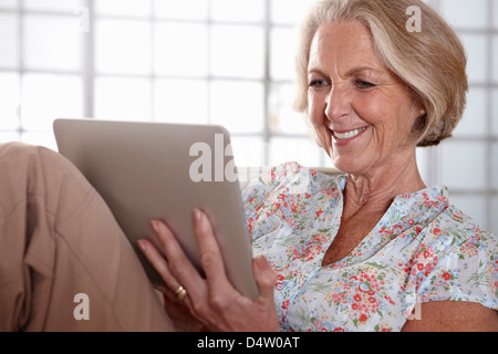 Donna anziana utilizzando computer tablet Foto Stock