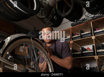 Meccanico che lavora nel negozio di biciclette Foto Stock