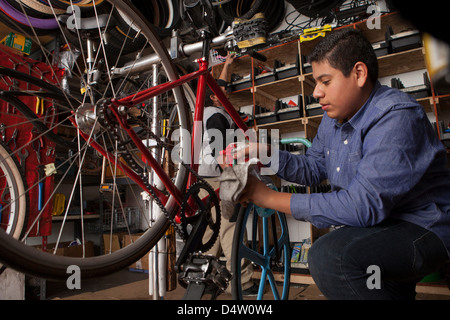 Meccanico che lavora nel negozio di biciclette Foto Stock