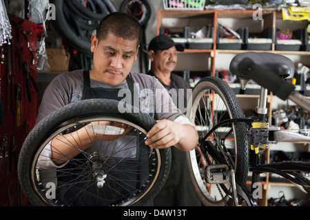 Meccanico che lavora nel negozio di biciclette Foto Stock