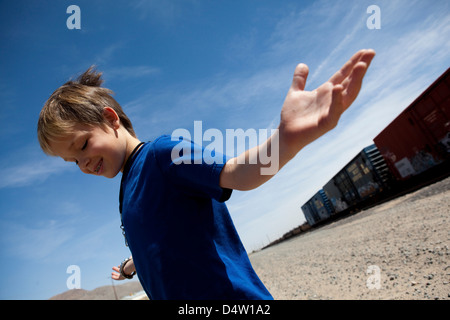 Ragazzo scrollare dai binari del treno Foto Stock