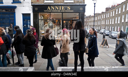 I clienti in coda in un freddo giorno di marzo per un ristorante al di fuori di Annie vintage del negozio di abbigliamento a Camden Passage, Londra Inghilterra KATHY DEWITT Foto Stock