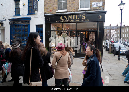 I clienti in coda in un freddo giorno di marzo per un ristorante al di fuori di Annie vintage del negozio di abbigliamento a Camden Passage, Londra Inghilterra Foto Stock