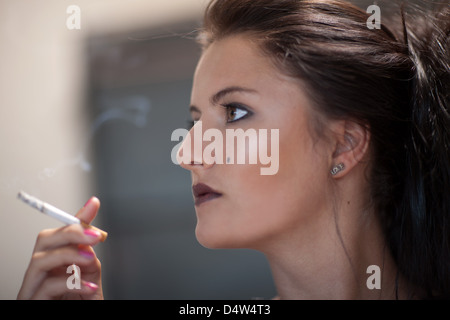 Ragazza adolescente in dark trucco fumatori Foto Stock