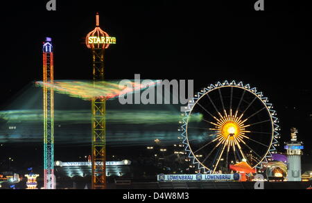 Das Fahrgeschäft Starflyer und dahinter das Riesenrad, aufgenommen am Samstag (18.09.2010) in München (Alta Baviera) auf dem Oktoberfest. Das größte Volksfest der Welt feiert heuer sein 200-jähriges Bestehen. Zum ersten mal in der Geschichte der Wiesn gilt ein Rauchverbot für die Bierzelte. Foto: Tobias Hase dpa/lby Foto Stock