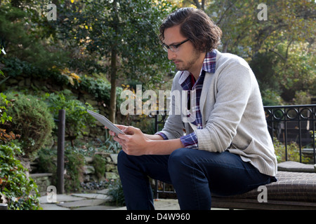 Uomo che utilizza computer tablet all'aperto Foto Stock