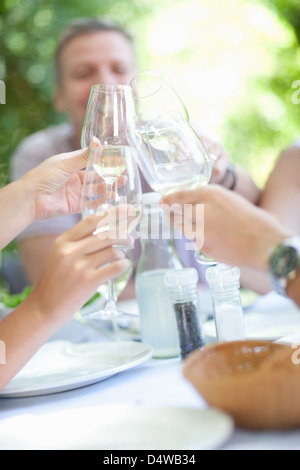 Famiglia tostare ogni altro a tavola Foto Stock