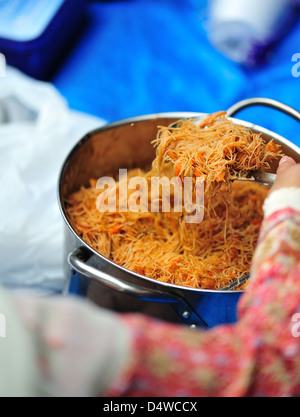 La ragazza che serve noodles fritti Foto Stock