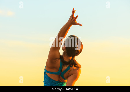 Donna pratica lo yoga al tramonto Foto Stock